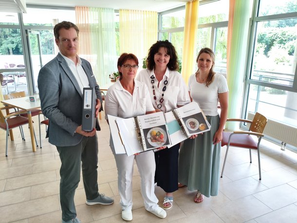 Ein Mann und 3 Frauen mit Speisenkatalog