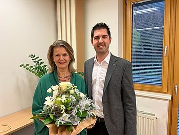 Herr Stephan Zöchling gratuliert Frau Bauer und überreicht ihr einen Blumenstrauß.