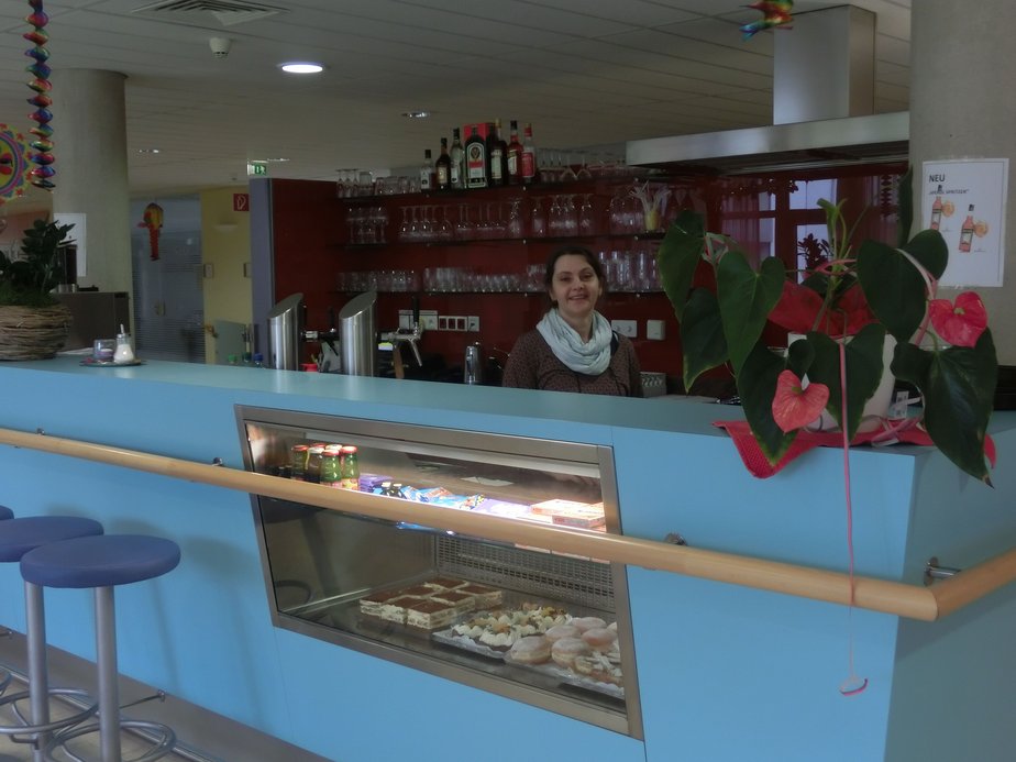 Eine Frau steht hinter einer blauen Theke.