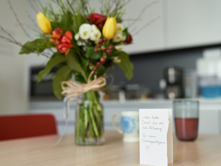 Eine Karte und Blumen stehen auf einem Tisch.