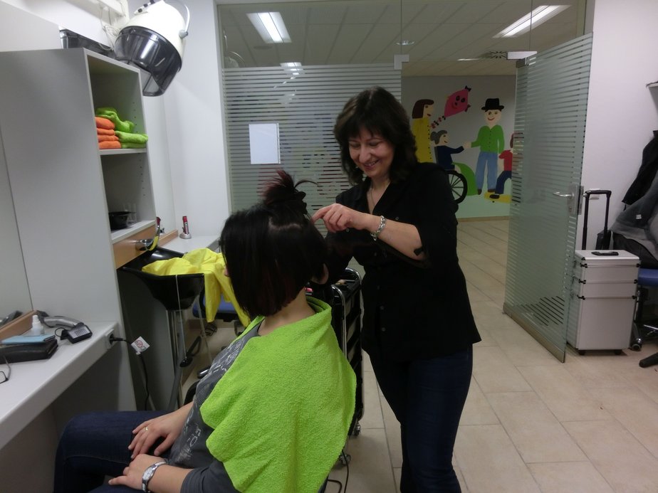 Die Friseurin schneidet einer Frau die Haare.