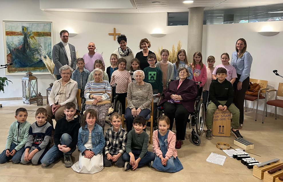 Gruppenfoto der Volksschulkinder mit den BewohnerInnen, Herrn Direktor Stefan Bernhard, MA und Frau Direktorin Maria Hollerer, MSC